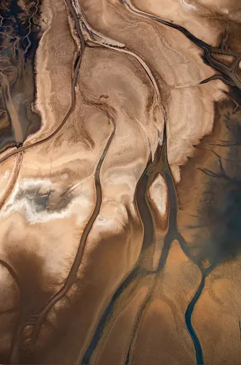 Rivierdelta in bruin en blauw vanuit vogelperspectief