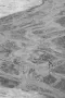 giraffe standing in almost dry river with spreaded legs